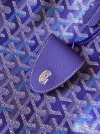 Blue patterned fabric tote bag with purple leather tab and circular logo emblem