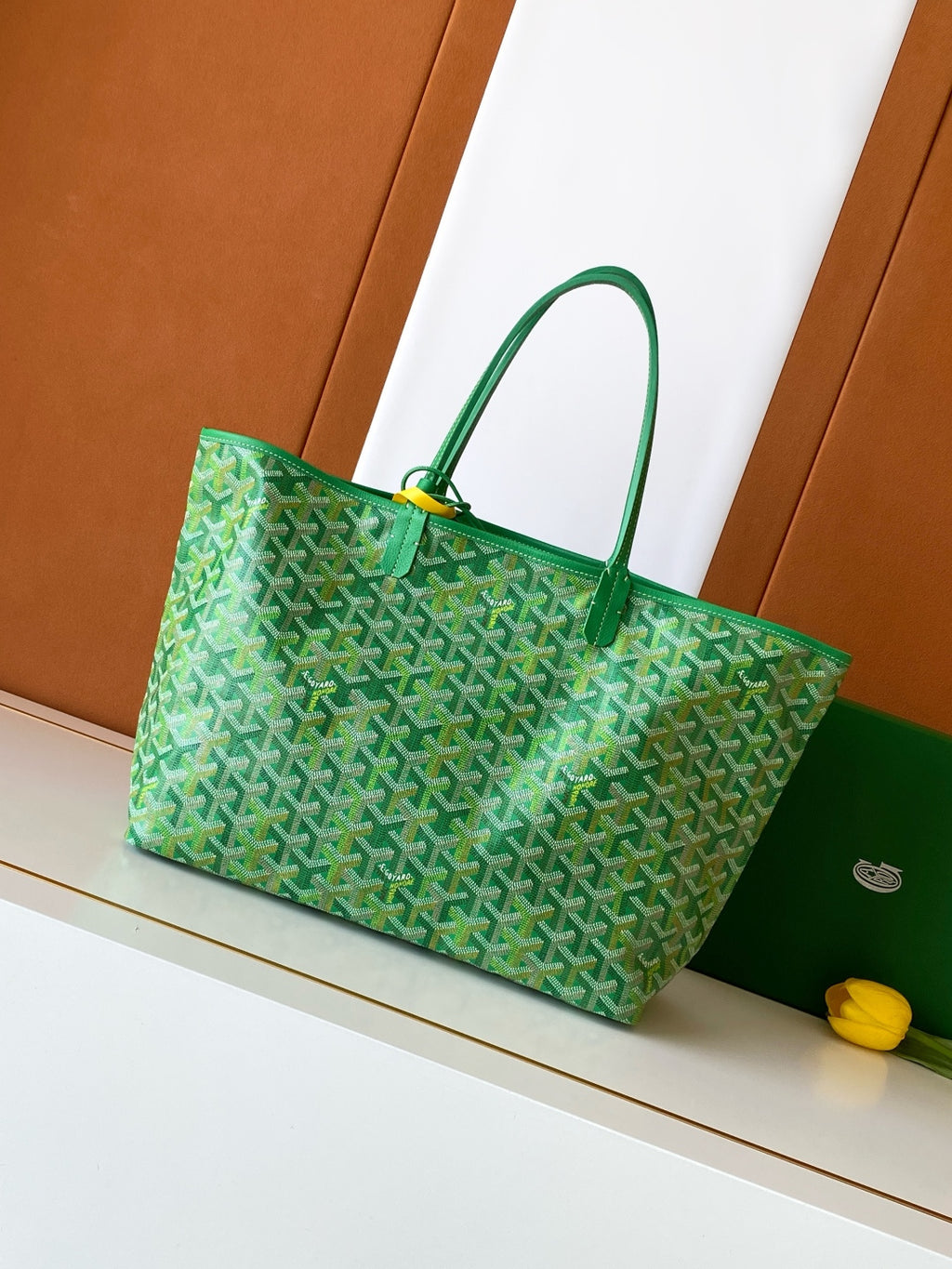 Green patterned tote bag with top handles and structured shape