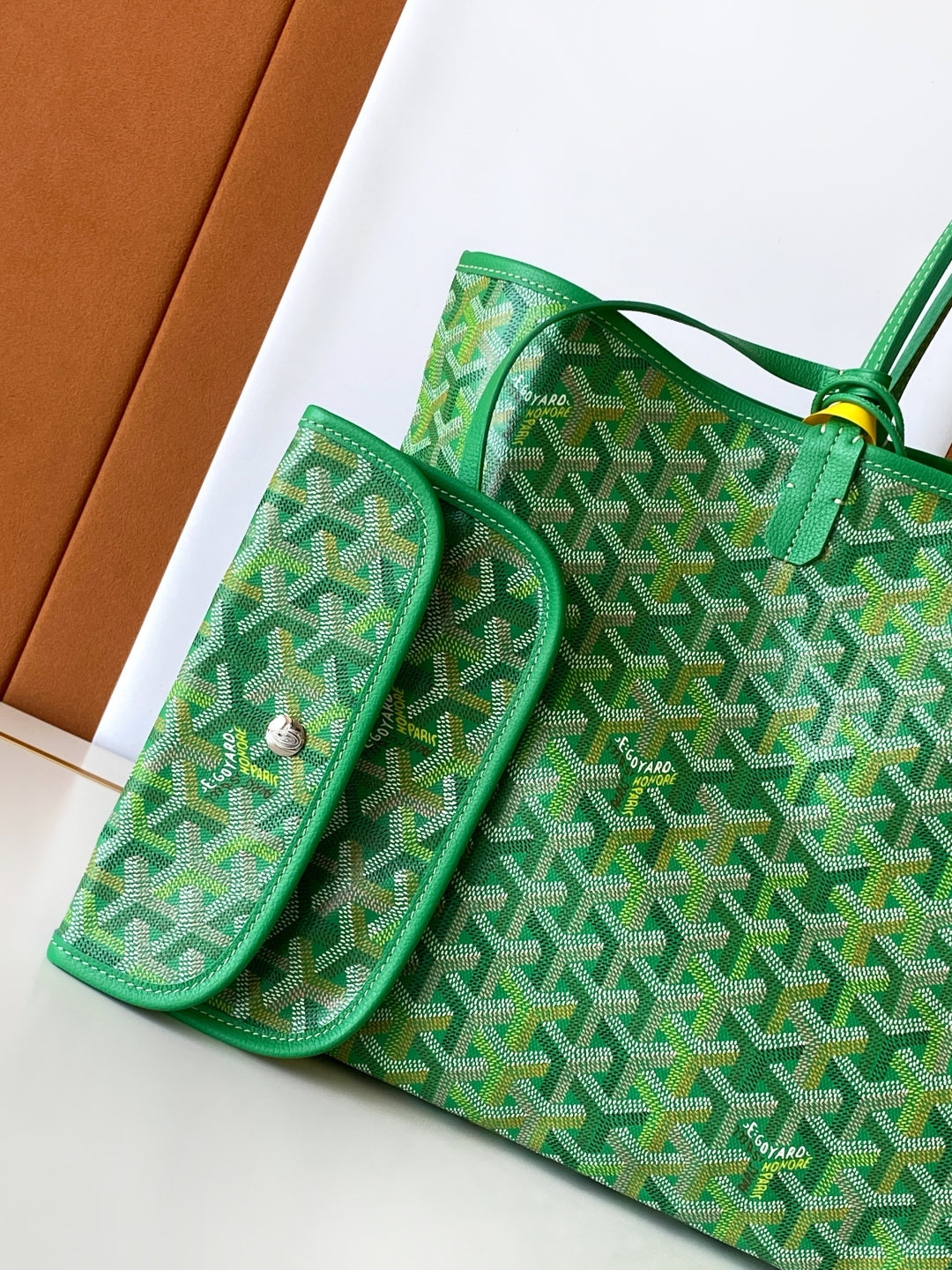 Green patterned tote bag with front flap pocket and small side compartments