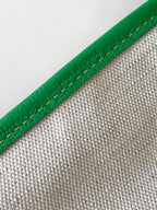 Green leather-trim tote bag edge with visible stitching and textured exterior