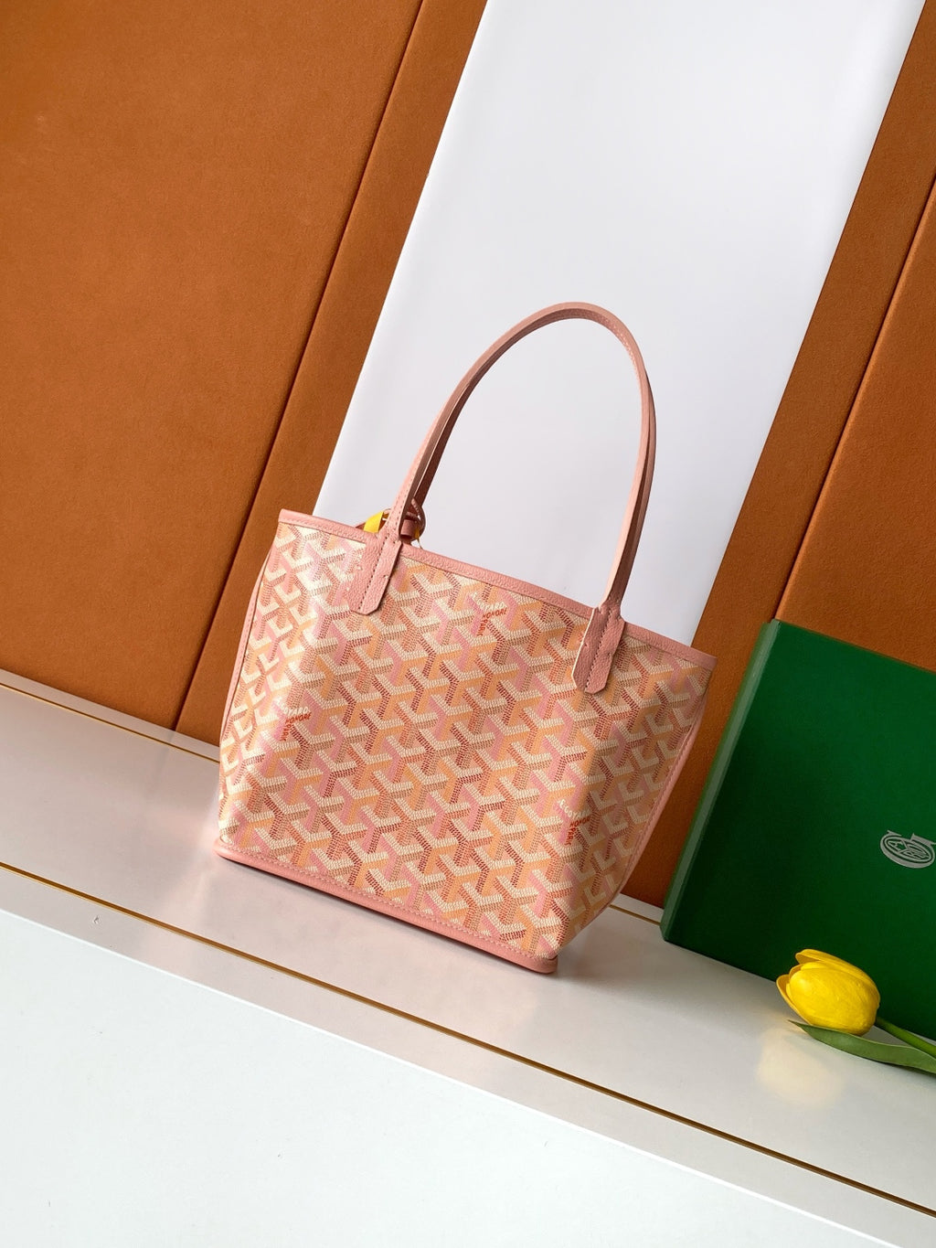 Pink patterned tote bag with leather-look handles and structured sides.