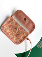 Small pink patterned pouch with button closure and leather trim.