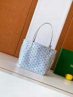 Light blue monogram tote bag with gold-tone hardware and top handles
