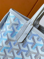 Close-up of light blue patterned tote bag pocket and stitched leather tab