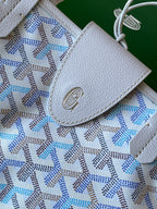Light blue patterned tote bag flap with embossed logo medallion