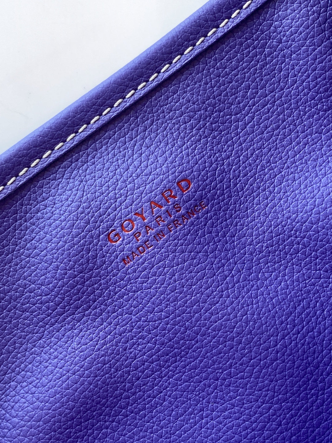 Goyard tote bag leather panel detail with embossed logo in blue