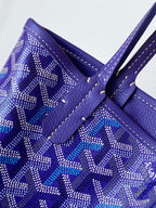 Goyard tote bag close-up, blue patterned panel with leather handle patch and contrast stitching