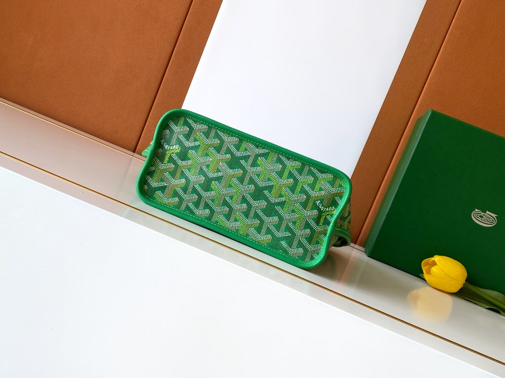 Green patterned clutch-style bag with top handle and rounded shape