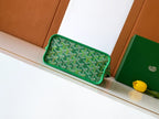 Green patterned clutch-style bag with top handle and rounded shape