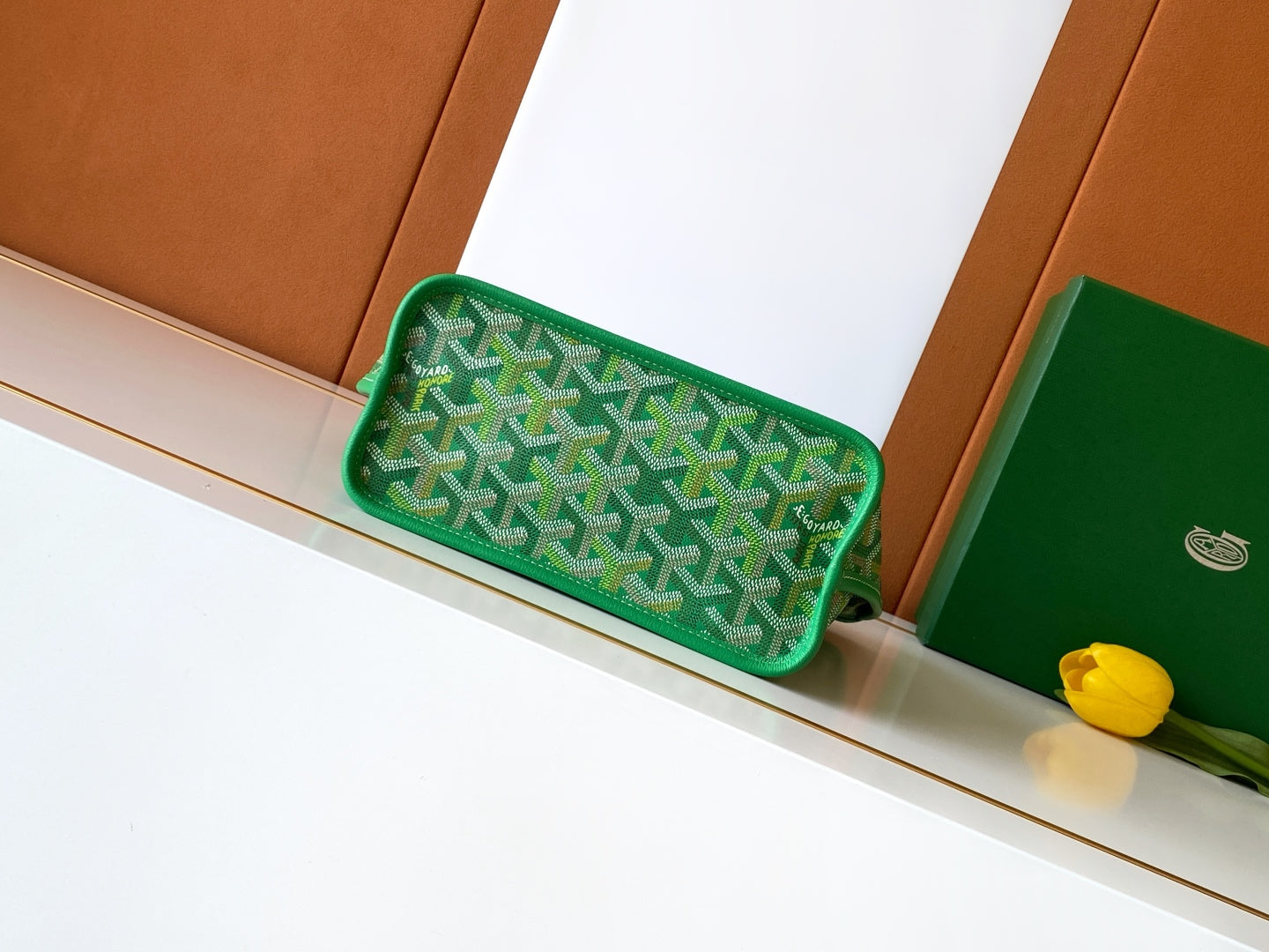 Green patterned clutch-style bag with top handle and rounded shape