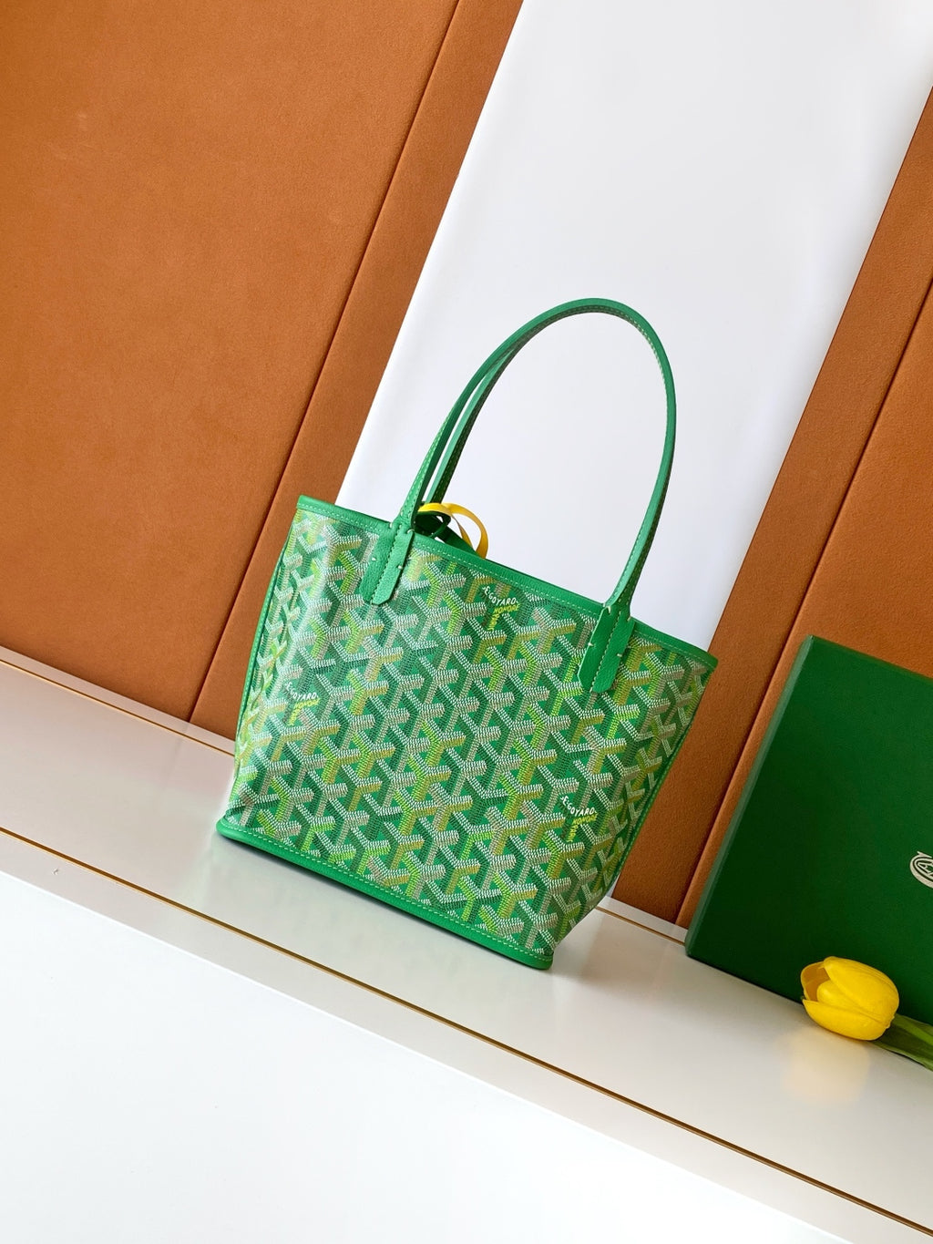 Green patterned tote bag with top handles and gold-tone hardware