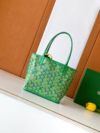 Green patterned tote bag with top handles and gold-tone hardware