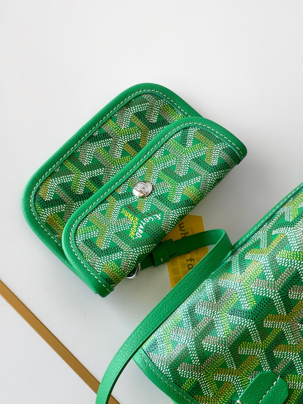 Green patterned pouch wallet with zipper pull and snap closure