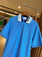 Blue Burberry polo shirt close-up on hanger, ribbed collar with button placket