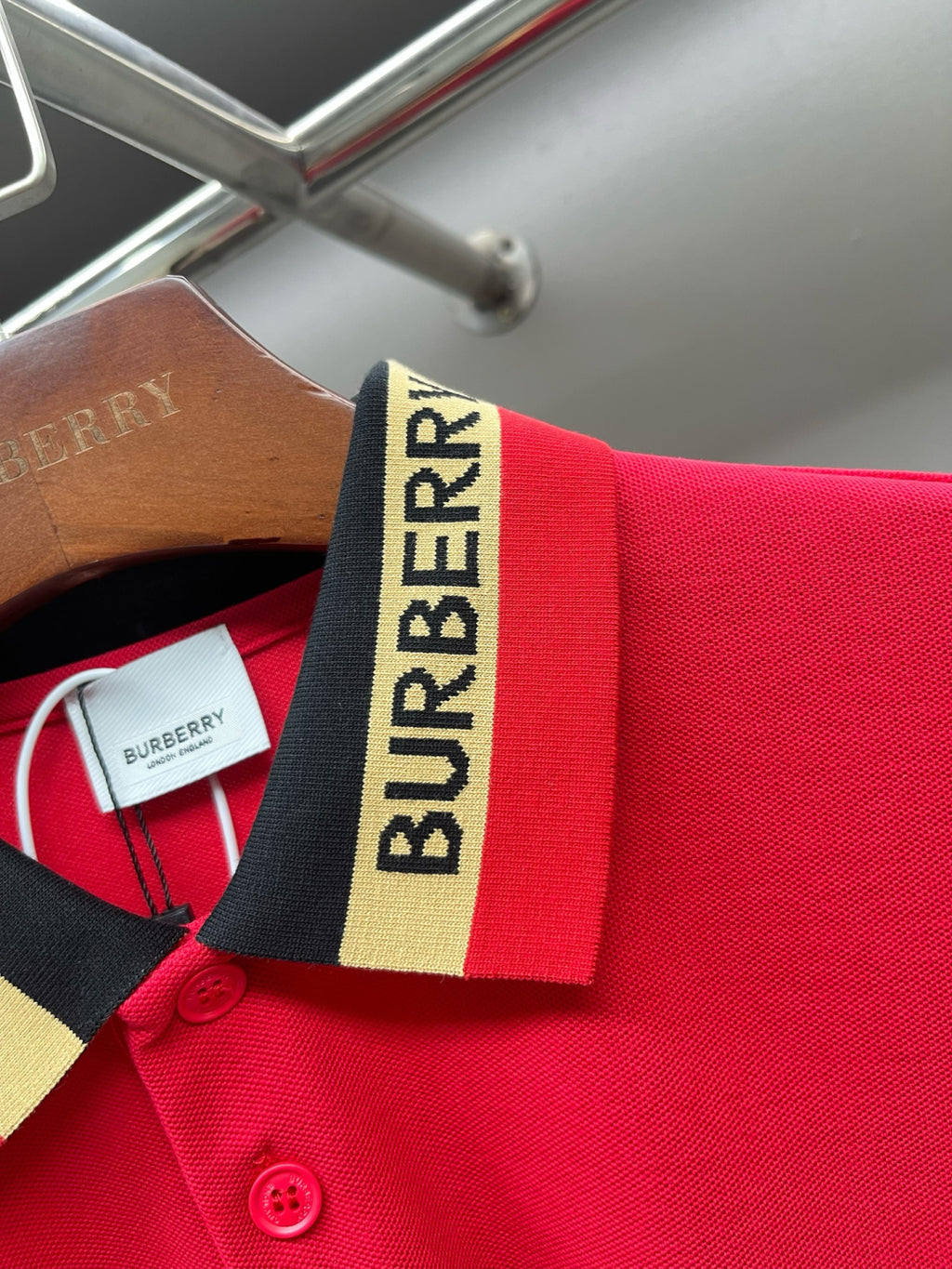Red polo shirt close-up of striped collar with Burberry label and buttons