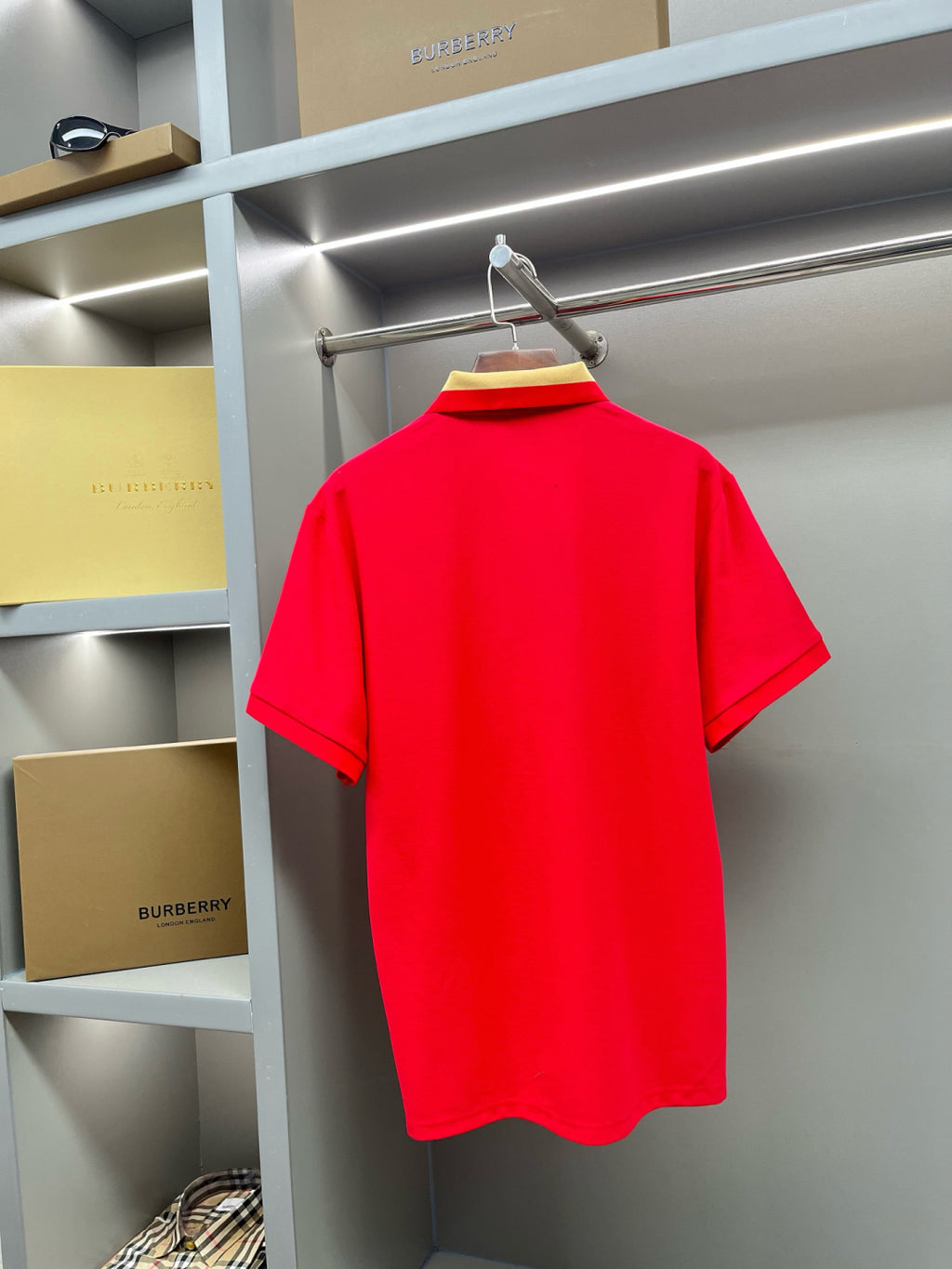 Red polo shirt back view on hanger