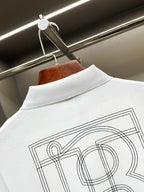 Close-up of white polo shirt back collar with large outlined monogram