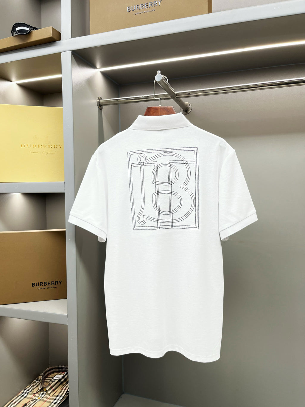 White Burberry polo shirt back view with large outlined monogram graphic