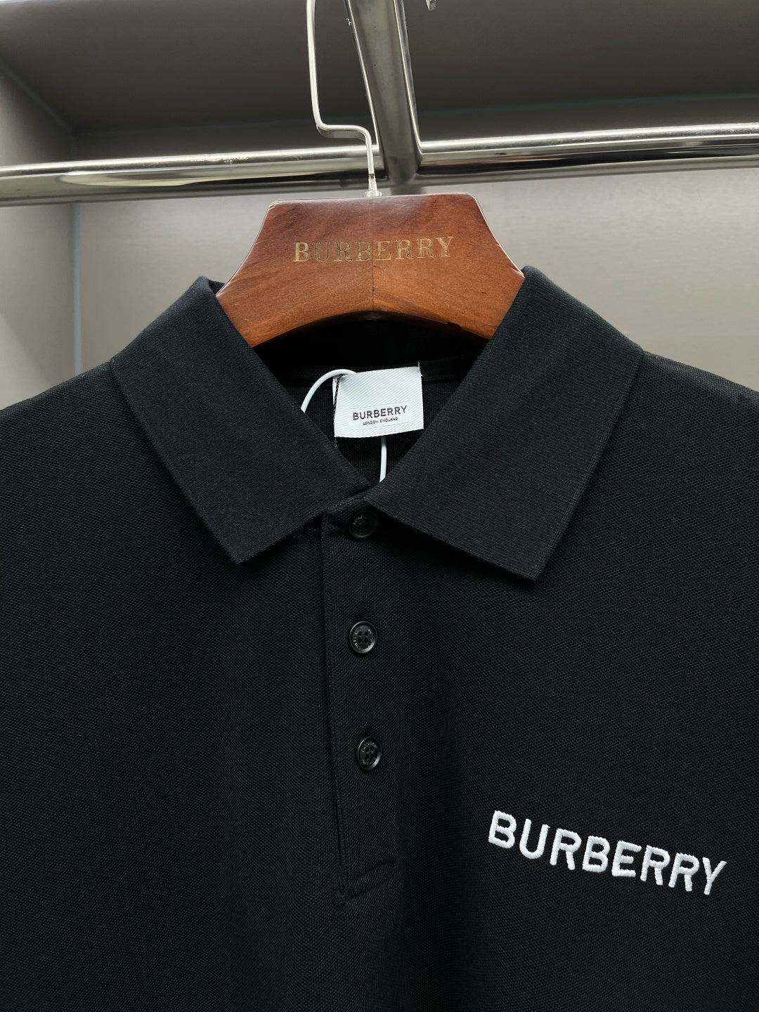 Black short-sleeve polo shirt, collar and Burberry logo print at chest.
