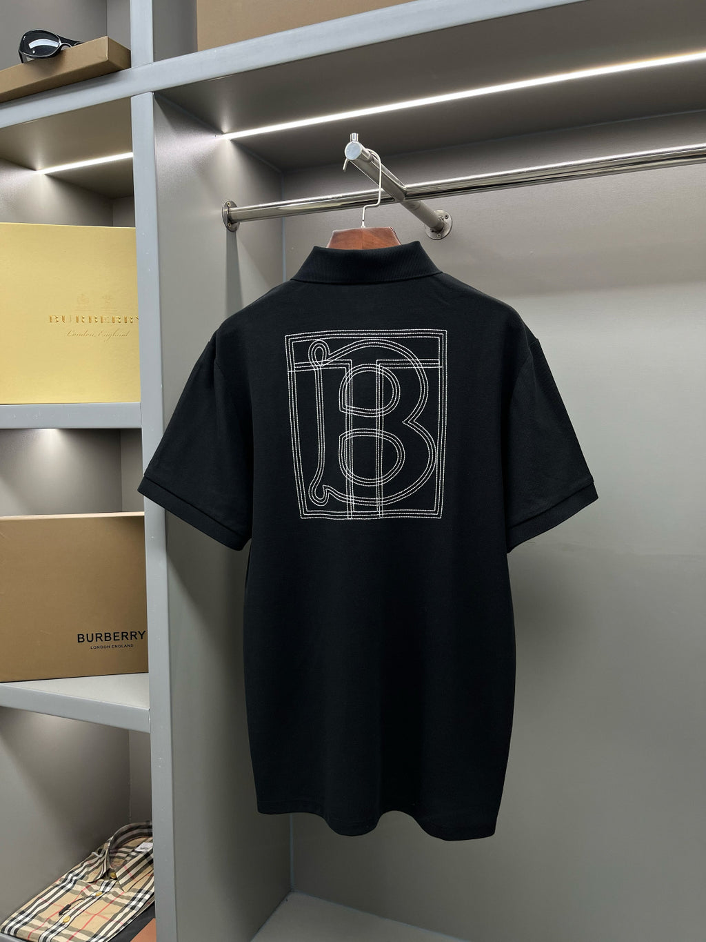 Black polo shirt with large back graphic print and Burberry logo label.