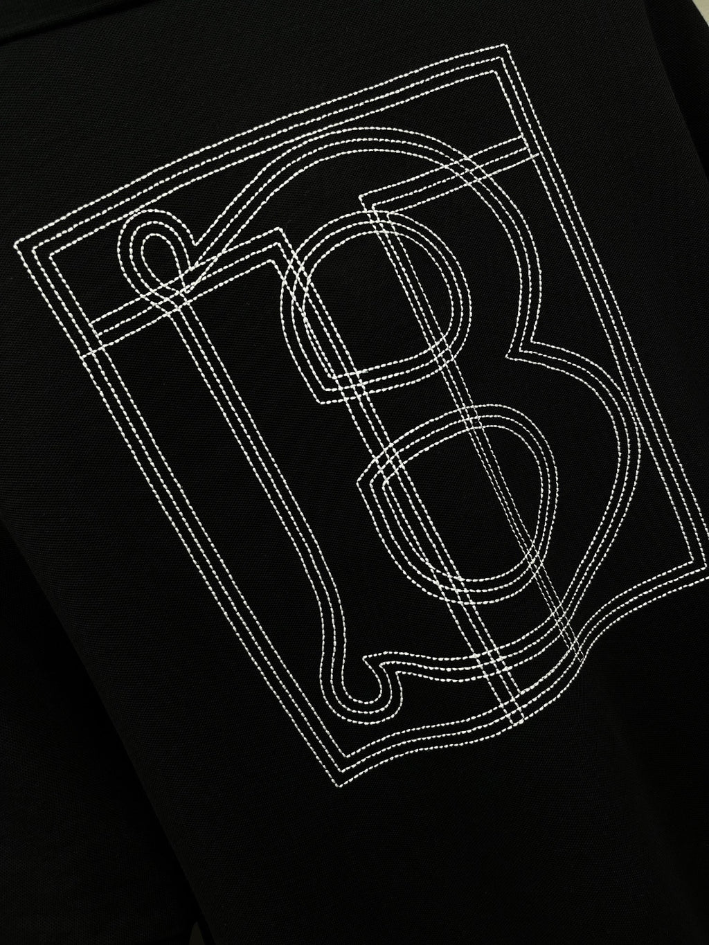 Black polo shirt back graphic print with outlined letters and number-style design.