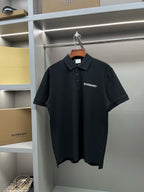 Black short-sleeve polo shirt with Burberry logo on left chest, button placket.