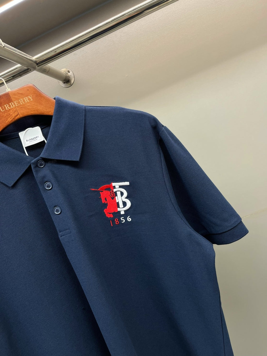 Dark blue polo shirt with red and white chest logo on front