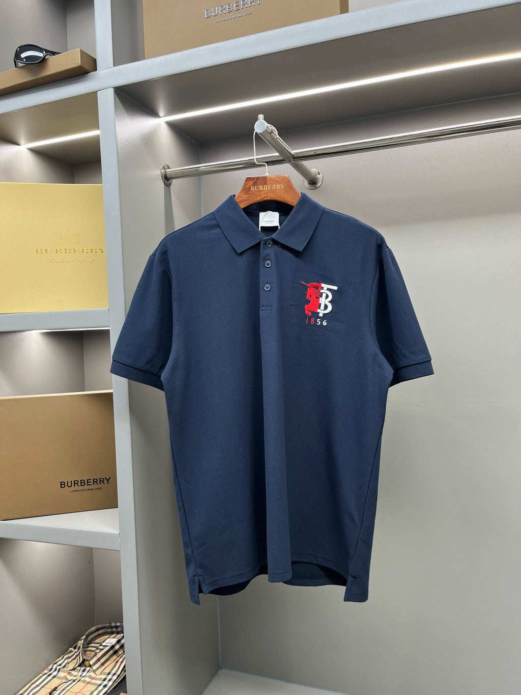 Dark blue polo shirt with button placket and red chest logo