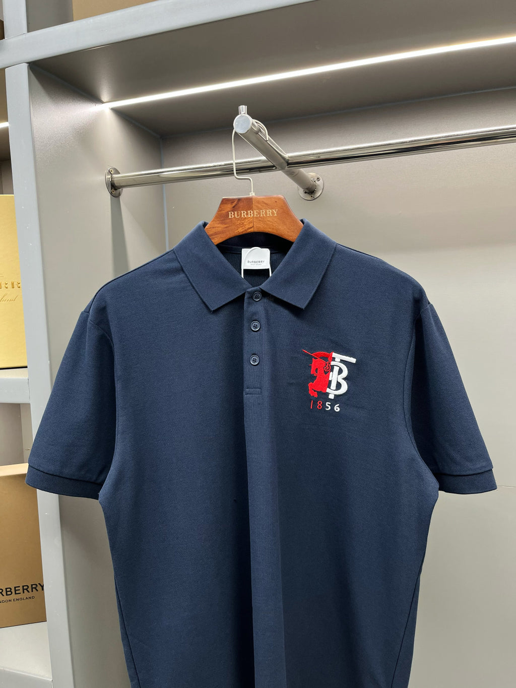 Dark blue polo shirt with pointed collar and red chest logo