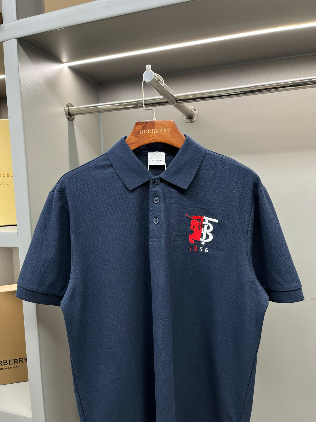 Dark blue polo shirt with pointed collar and red chest logo