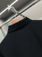 Close-up of black polo shirt shoulder and collar seam at the back.