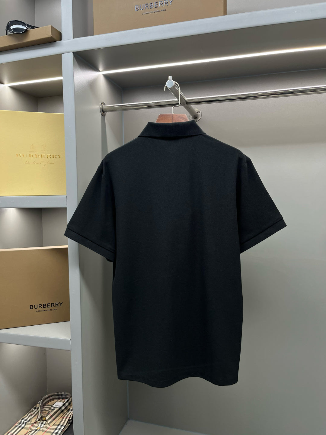 Black short-sleeve polo shirt back with plain knit and no visible logo.