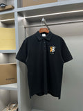 Black short-sleeve polo shirt with button placket and embroidered TB 1856 logo.