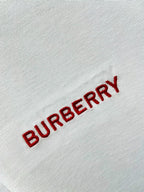 Burberry red logo embroidery on white polo shirt fabric