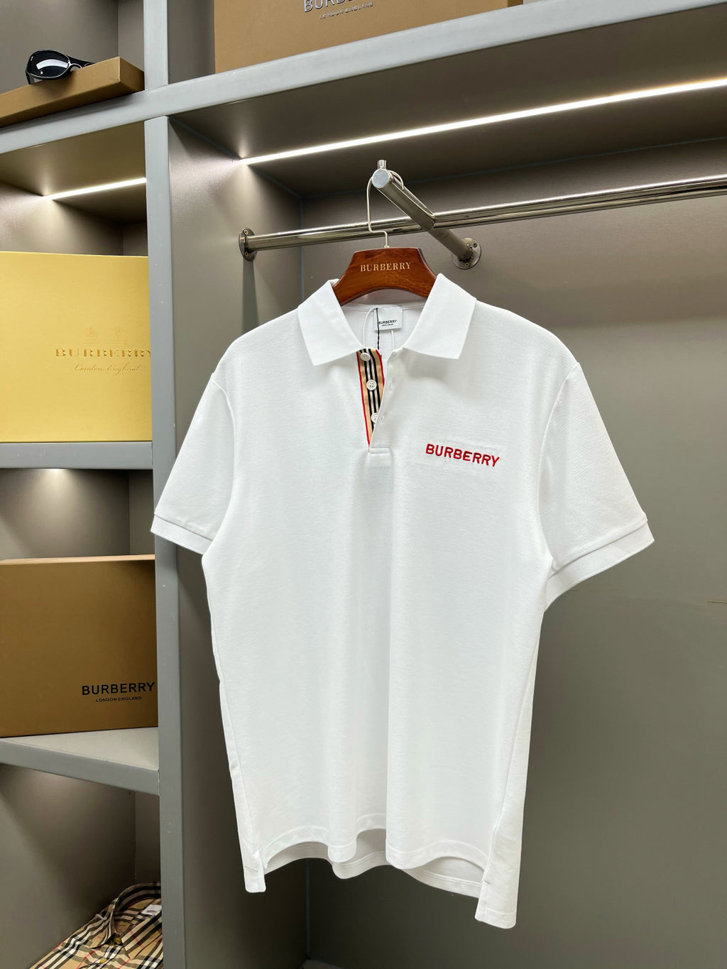 Burberry white polo shirt on hanger with red logo at the chest