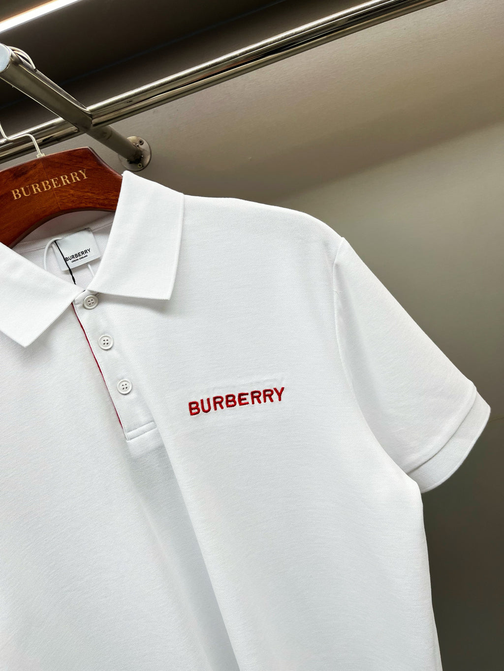 Burberry white polo shirt with red Burberry logo on chest and button details