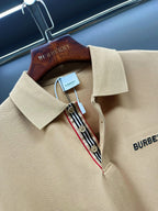 Beige polo shirt neckline detail with Burberry logo patch, button placket, striped trim