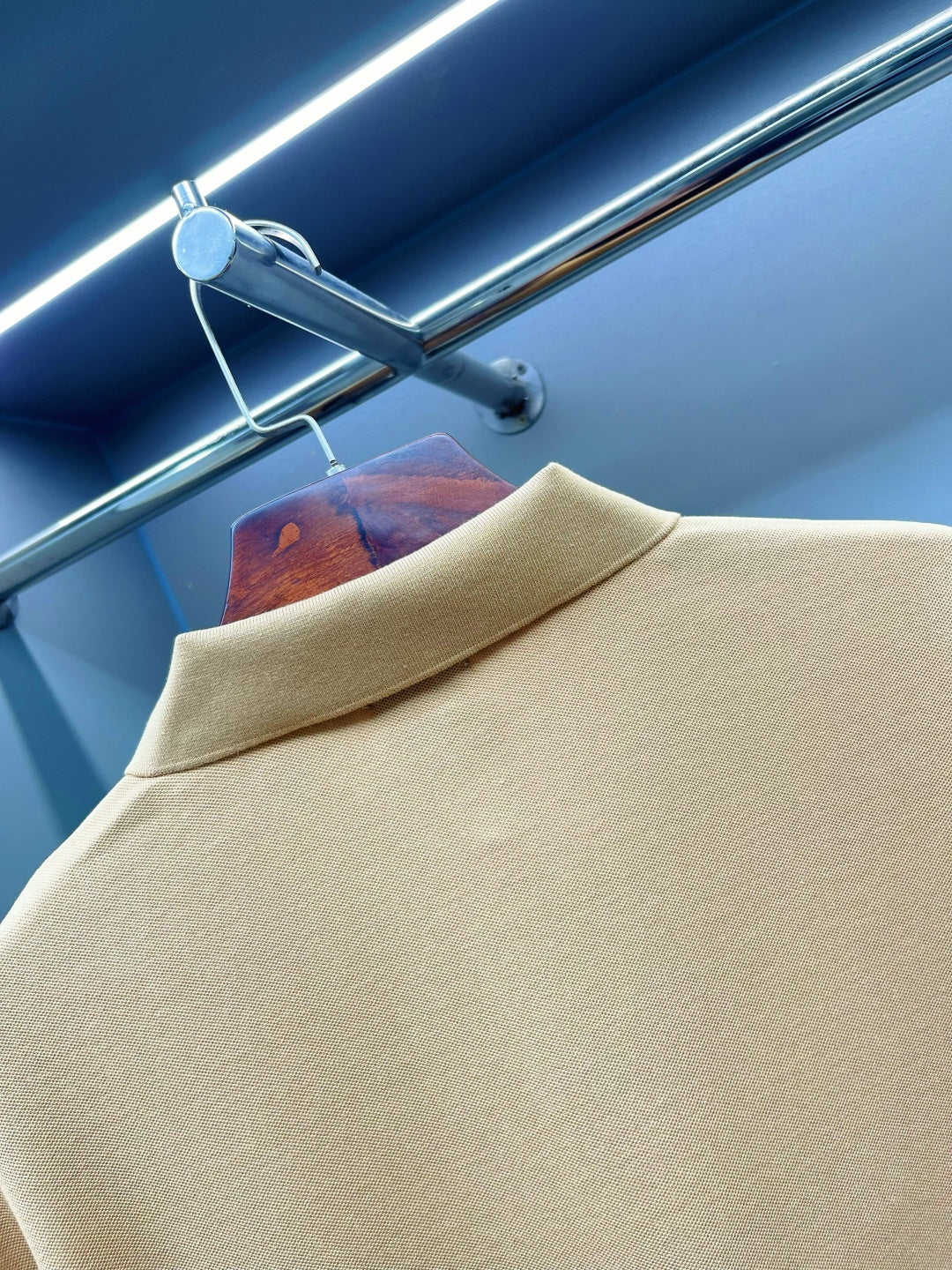 Beige polo shirt collar close-up with textured fabric and short sleeves