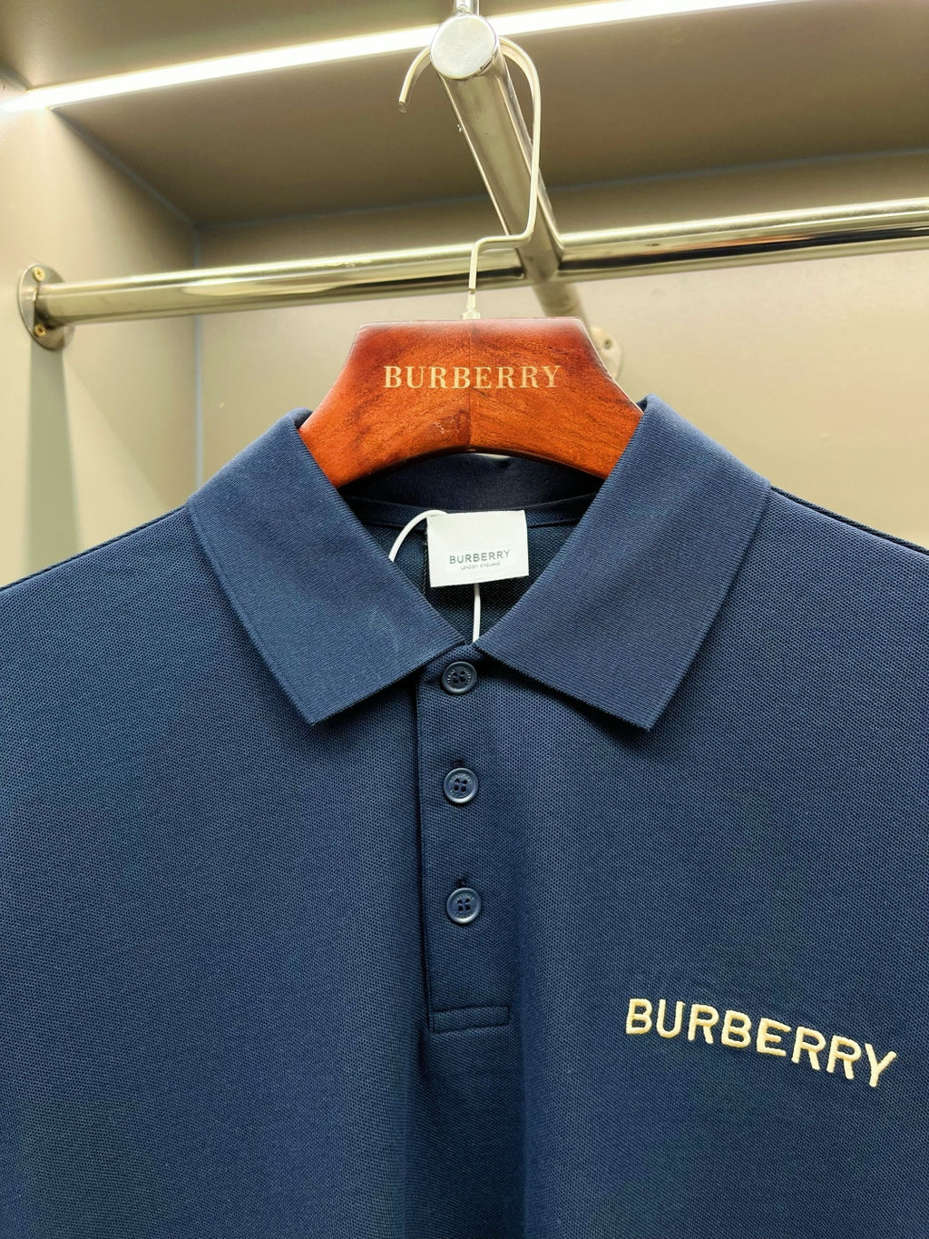 Close-up of blue Burberry polo shirt chest logo and button placket