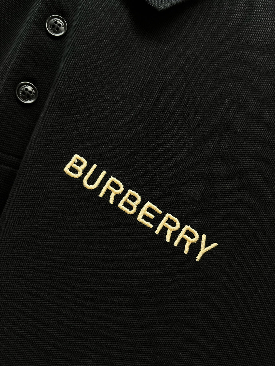 Burberry logo embroidery on dark polo fabric