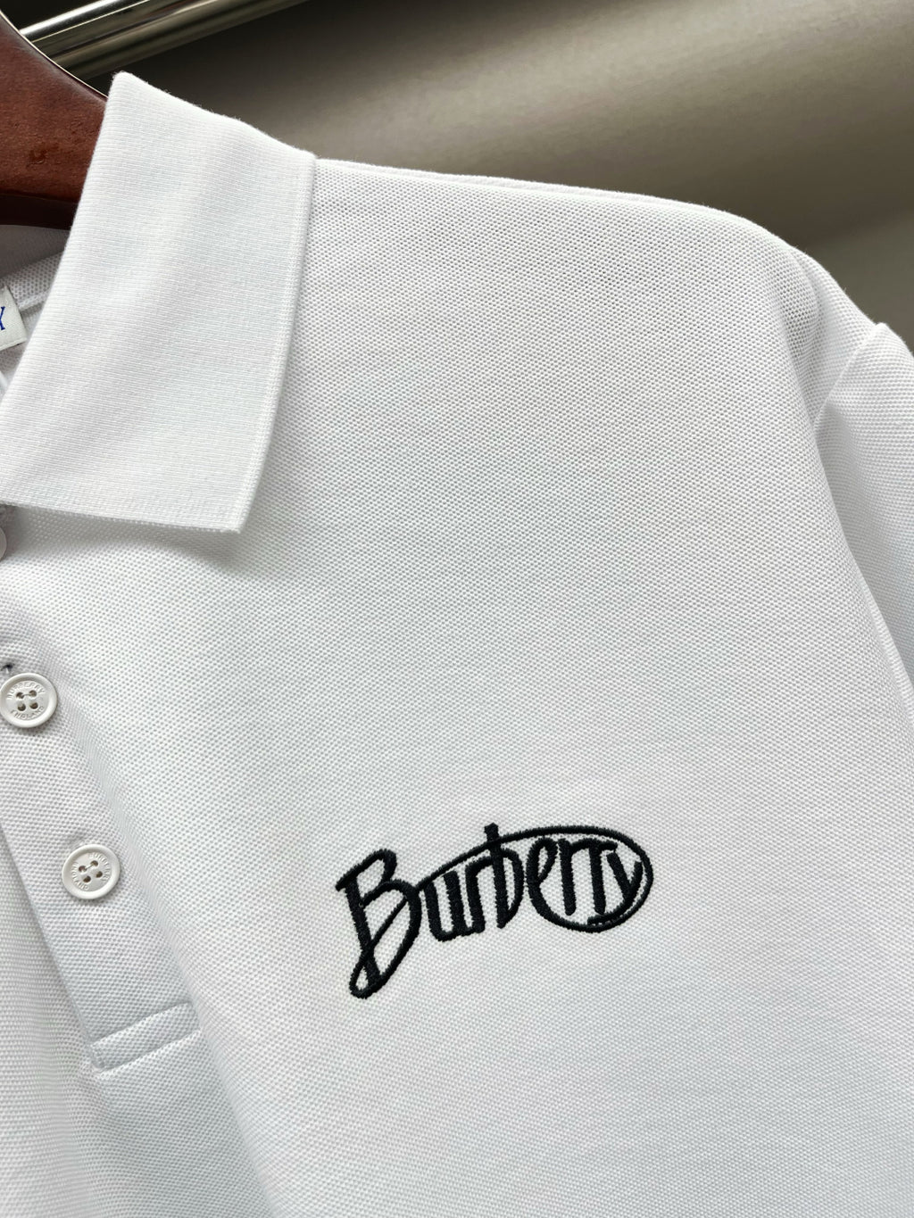 Burberry white short-sleeve polo shirt close-up of chest logo on knit fabric