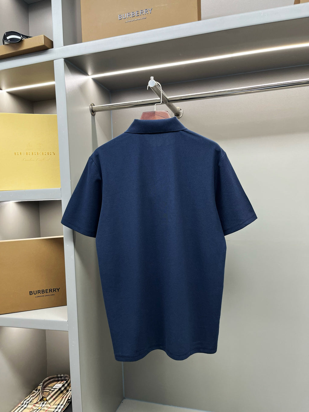 Navy Burberry polo shirt back view on hanger, short sleeves