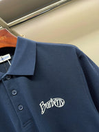Navy Burberry polo shirt detail: collar, buttons, Burberry logo embroidery