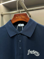 Navy Burberry polo shirt close-up: spread collar, three-button placket, chest logo