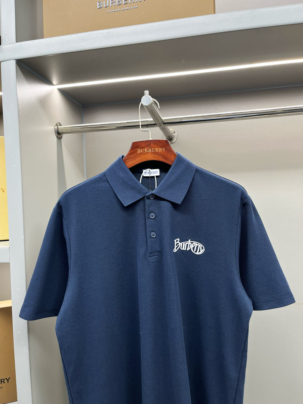 Blue Burberry polo shirt on hanger, short sleeves, button placket, chest logo