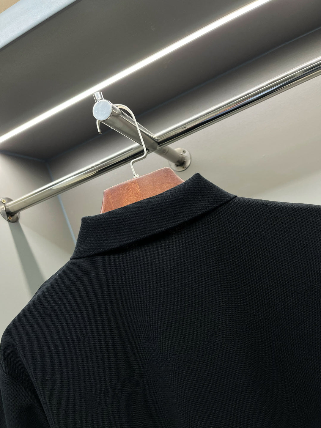 Back of dark navy polo shirt with wide collar and no visible front print