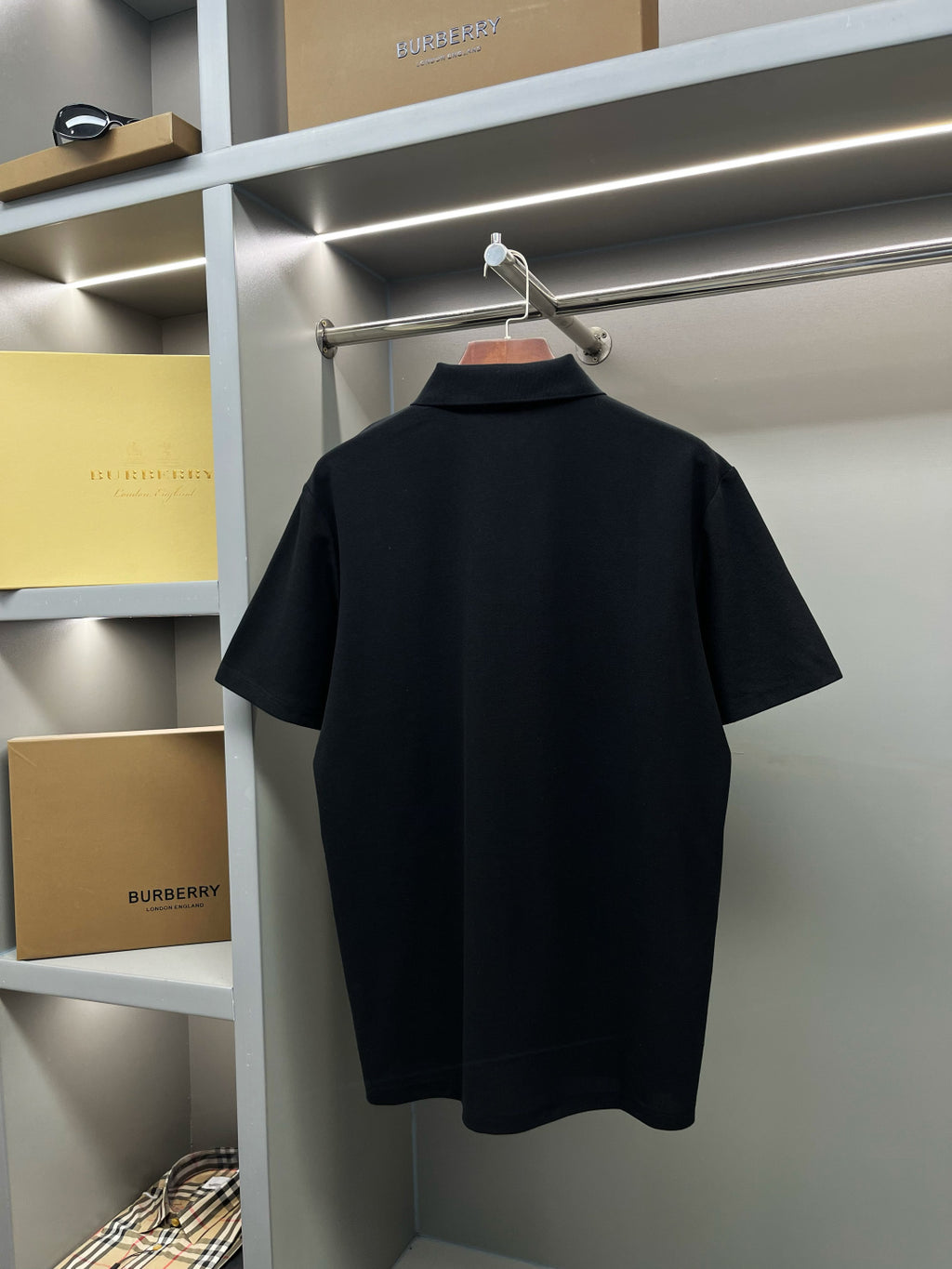 Dark navy short-sleeve polo shirt on hanger, plain back view