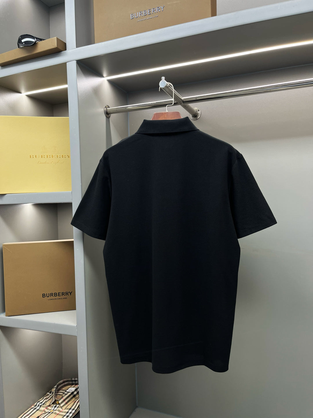 Dark navy short-sleeve polo shirt on hanger, plain back view