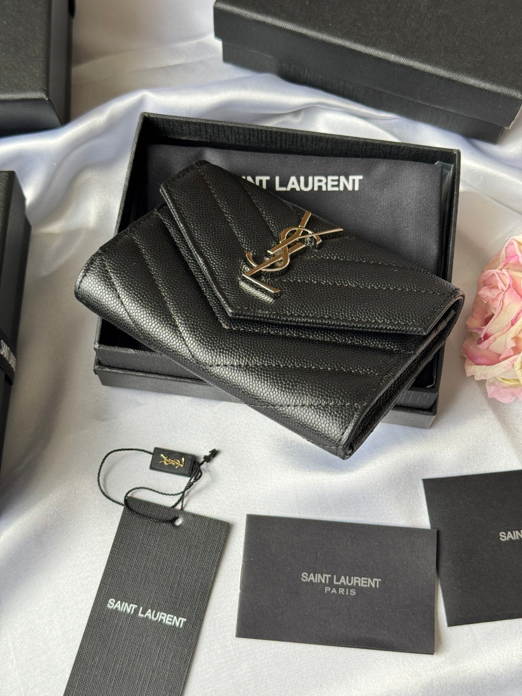 Dark small bag with flap and YSL gold logo, shown at an angle