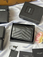 Dark small bag with chevron-textured front in open gift box